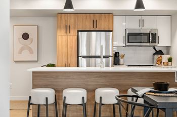 a kitchen with a breakfast bar and a stainless steel refrigerator